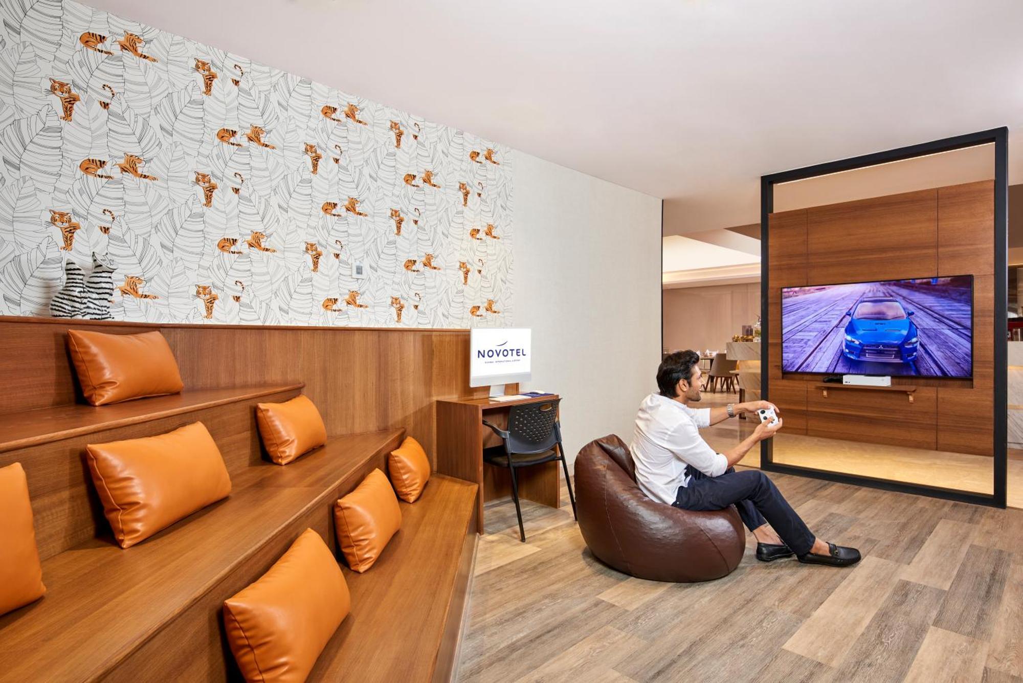 Novotel Mumbai International Airport Exterior foto A man playing a video game at the lounge
