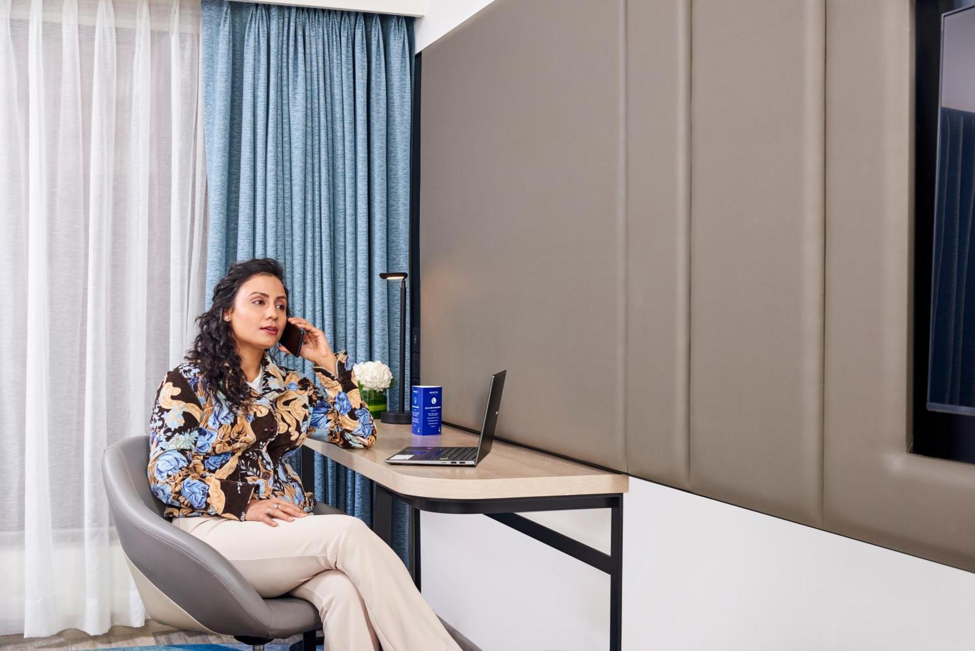 Novotel Mumbai International Airport Exterior foto A woman working from home